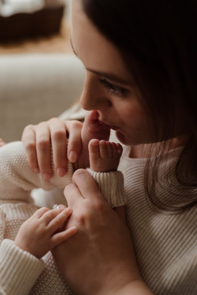 Photo of Mum kissing four month old baby feet at home in Hampshire