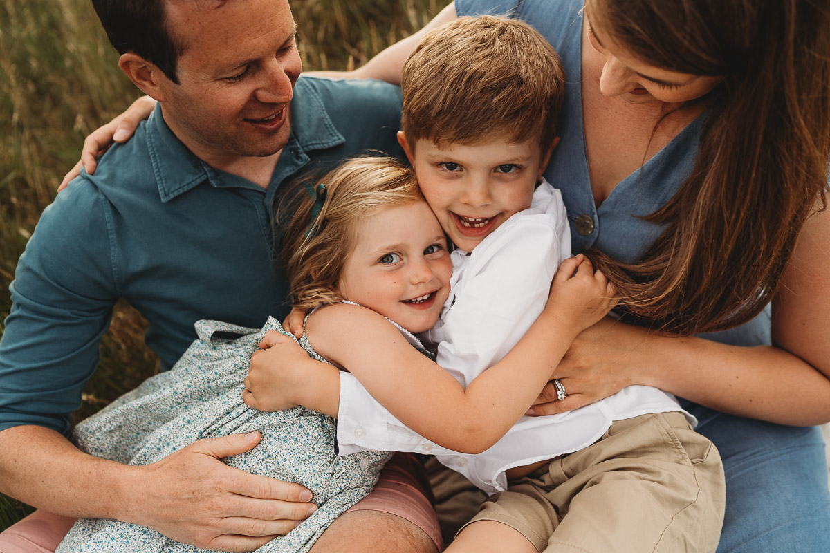family snuggles in the summer fields