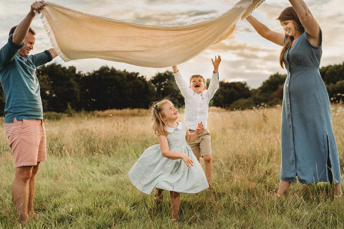 family having fun under blanket