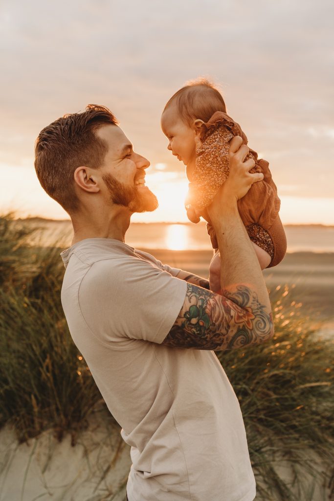 baby and dad in the golden glow of the sunset