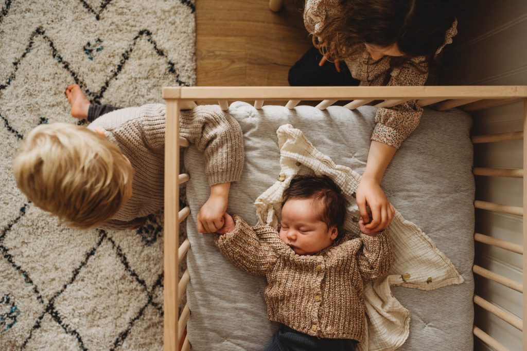 family photos around newborn baby in crib natural relaxed newborn photography southampton