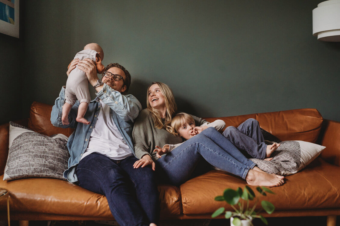 at home family photos on the couch smiling laughing fun natural relaxed newborn photography southampton