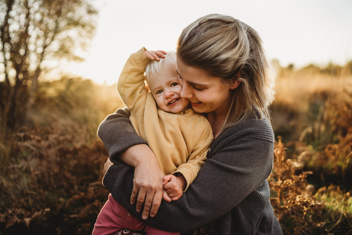 sunset family photos , lifestyle family photographer Southampton, Hampshire, Carley Aplin, relaxed -1-8 Image of a newborn baby taken from above their head looking down on them wearing a white bow in a cream sleep seat sleeping with long beautiful eyelashes