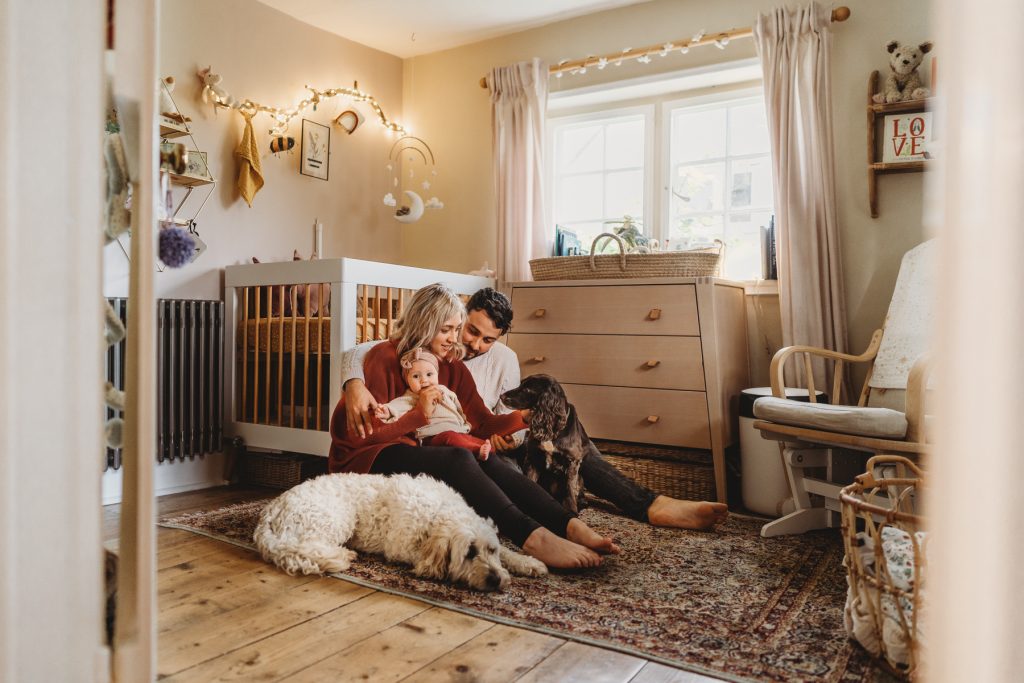 mother and father with newborn baby on the floor of the nursery at home in Salisbury Wiltshire 