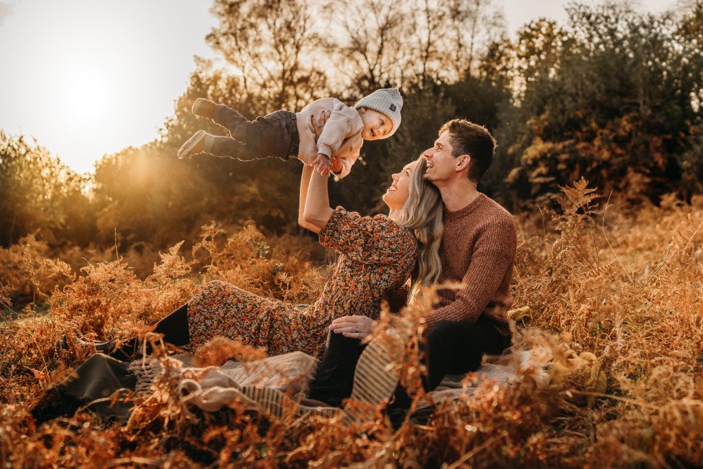 family in the golden sun on a hillside in the new forest, family photoshoot in Hampshire, Carley Aplin, 
