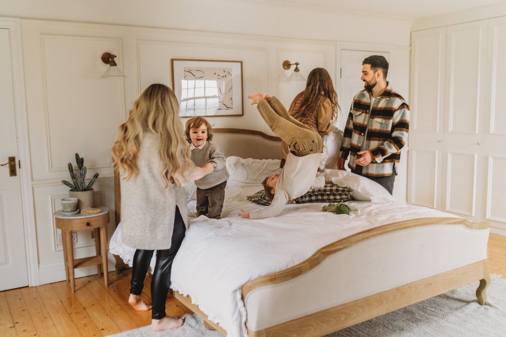 family having a pillow fight on the bed at home