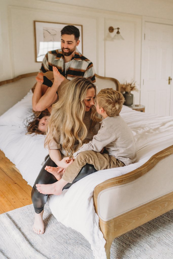 Family playing on the bed at home