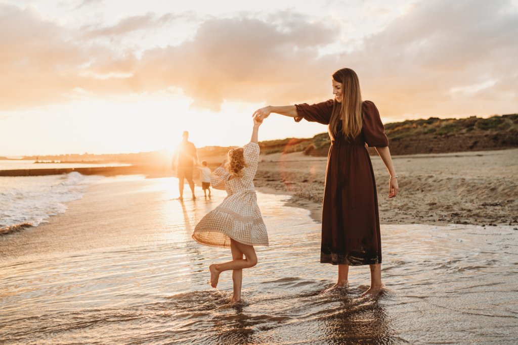 Playful family moments captured against a stunning evening sky