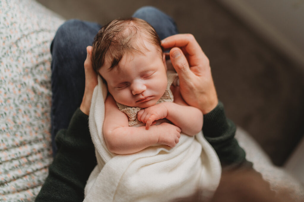 newborn photos of baby sleeping on dads lap
