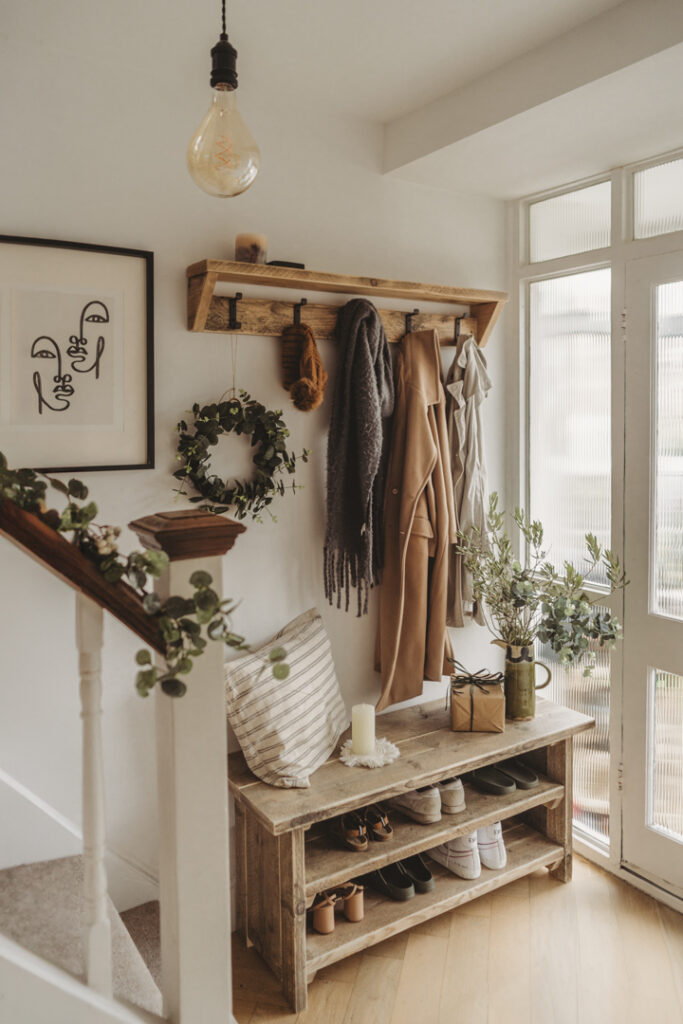 photo of a hallway with coats hanging above a hand made shoe rack by still and bloom 